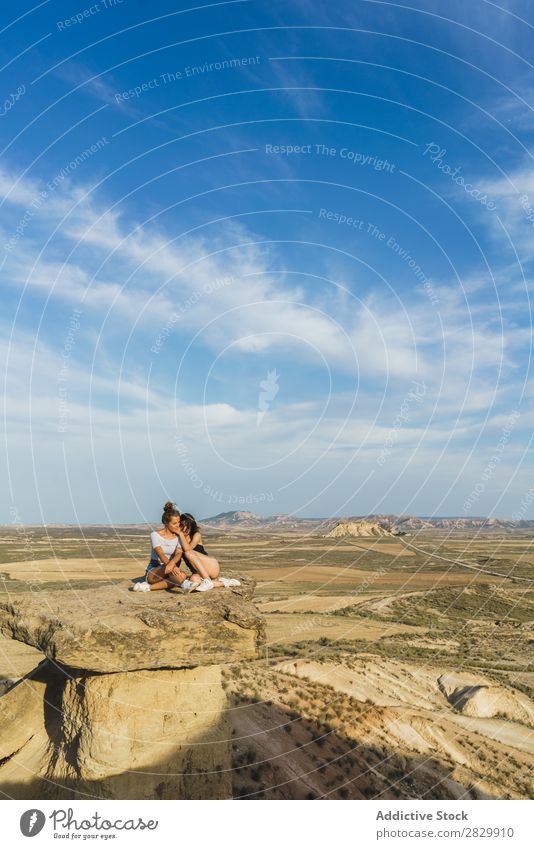 Aufgeregte Frauen, die auf einer Klippe liegen. Erholung Ferien & Urlaub & Reisen Abenteuer Felsen Berge u. Gebirge Tourist Freundschaft Zusammensein Lächeln