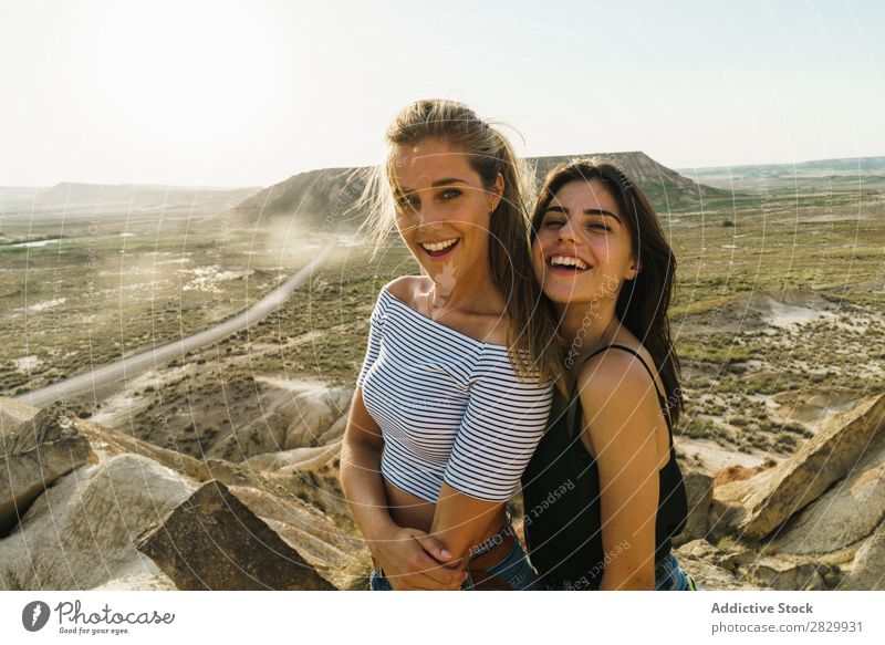 Fröhliche Frauen, die auf einer Klippe stehen. Aufregung umarmend Blick in die Kamera Lächeln heiter Umarmen Freiheit Ferien & Urlaub & Reisen Erfolg Top