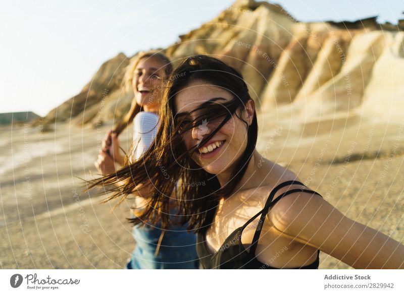 Hübsche Frauen, die auf dem Hügel spazieren gehen. Aufregung Blick in die Kamera fliegendes Haar laufen heiter Freiheit Ferien & Urlaub & Reisen Erfolg Top