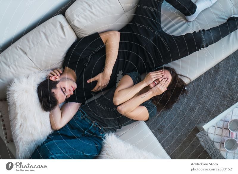 Paar auf dem Sofa liegend heimwärts Zusammensein lügen Liege gemütlich Mensch Glück Liebe Haus Mann Frau Lifestyle 2 Jugendliche Erwachsene Wohnung