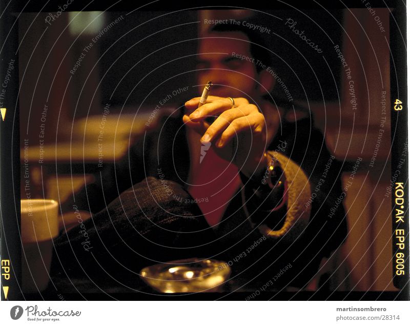 rauchen Aschenbecher gemütlich Mann hand die eine zigarette hält tiefenunschärfe Rauchen Abend Innenaufnahme