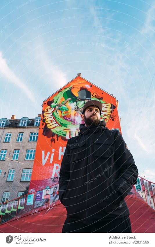 Mann steht zu Haus mit Graffiti gutaussehend Großstadt Wand Straße Jugendliche Stadt Lifestyle lässig Mode Stil Erwachsene modern Mensch trendy warme Kleidung