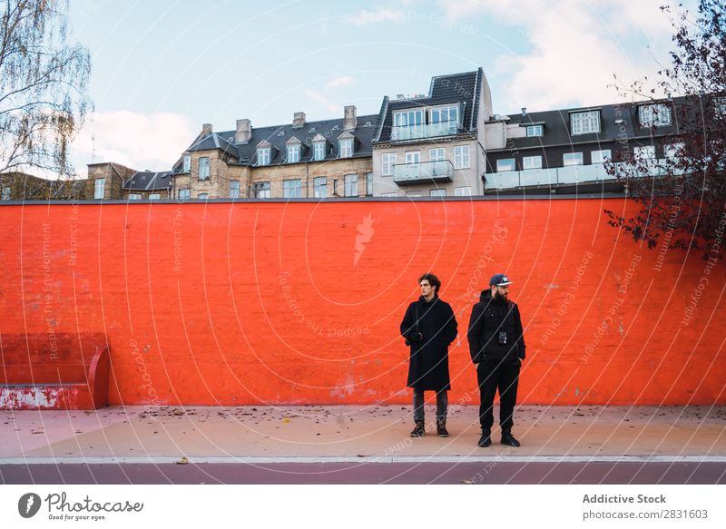 Zwei Männer an der orangefarbenen Wand Mann stehen Orange Zusammensein Straße gutaussehend Großstadt Jugendliche Stadt Lifestyle lässig Mode Stil Erwachsene