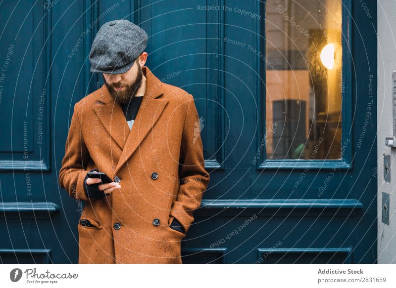 Nachdenklicher, stilvoller Mann an der Tür gutaussehend Großstadt Stil Mantel Hut Mütze Fürsorge besinnlich Straße Jugendliche Stadt Lifestyle lässig Mode