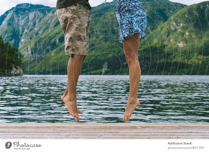 Erntepaar auf dem Pier posierend Paar Anlegestelle Freude See Berge u. Gebirge springen Glück Liebe Zusammensein Natur Sommer Wasser Jugendliche Frau