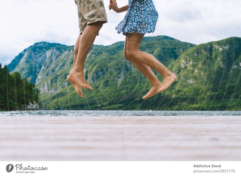 Erntepaar auf dem Pier posierend Paar Anlegestelle Freude See Berge u. Gebirge springen Glück Liebe Zusammensein Natur Sommer Wasser Jugendliche Frau