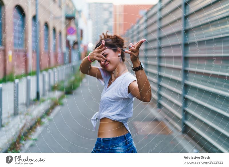 Stylisches ausdrucksstarkes Mädchen, das auf der Straße posiert. Frau Stil spielerisch gestikulierend Jugendliche Ferien & Urlaub & Reisen zeigen