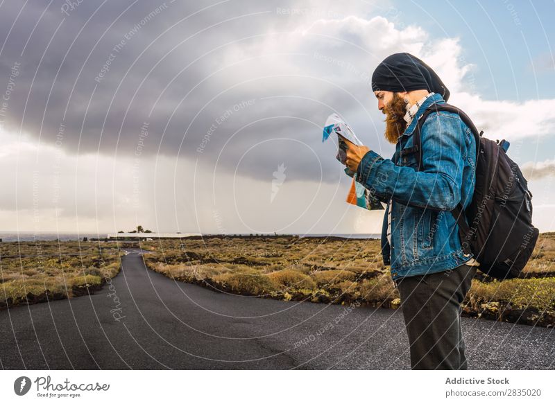 Tourist Mann mit Karte Feld Landkarte Navigation verirrt Rucksack stehen ruhen Wolken Natur Landschaft natürlich Lanzarote Spanien Aussicht