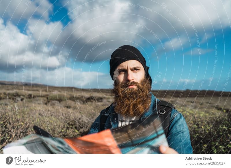 Touristischer Mann mit Karte und Smartphone Feld Landkarte Navigation verirrt Rucksack stehen ruhen Wolken Natur Landschaft natürlich Lanzarote Spanien Aussicht