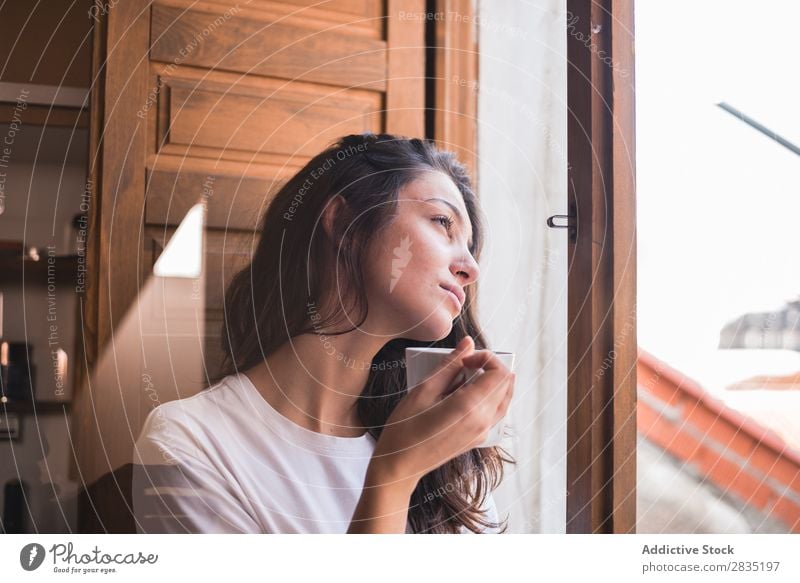 Nachdenkliche Frau mit einem Becher Tasse Fenster besinnlich träumen Fürsorge Blick trinken schön Jugendliche Beautyfotografie Mädchen Tee Kaffee heimwärts