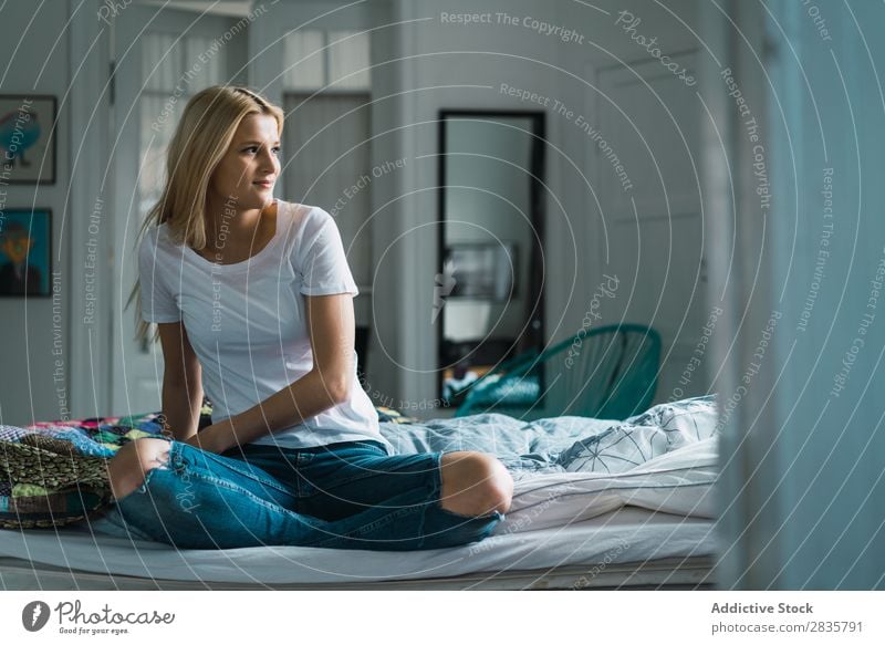 Frau auf dem Bett schaut weg. hübsch heimwärts Jugendliche blond sitzen träumen besinnlich schön Lifestyle Beautyfotografie attraktiv Porträt Dame Raum Mensch