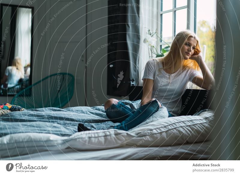Frau auf dem Bett schaut zum Fenster. hübsch heimwärts Jugendliche blond sitzen träumen besinnlich schön Lifestyle Beautyfotografie attraktiv Porträt Dame Raum