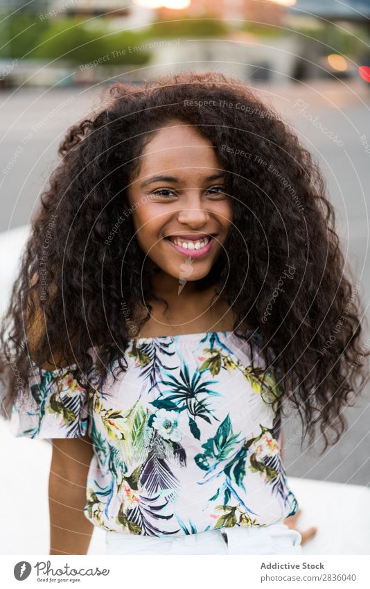 Junge schwarze Frau, die lächelt und in die Kamera schaut. hübsch Jugendliche Porträt Blick in die Kamera Afrikanisch Kopf schön lockig brünett Beautyfotografie