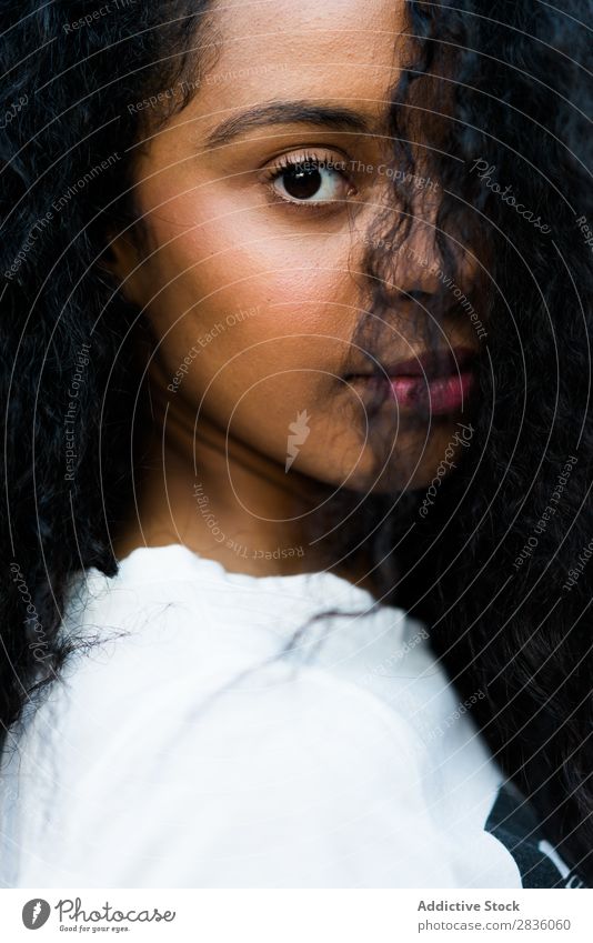 Nahaufnahme lockige Frau hübsch Jugendliche Porträt Blick in die Kamera Haltehaar schwarz Afrikanisch Kopf schön brünett Beautyfotografie Mädchen Model niedlich