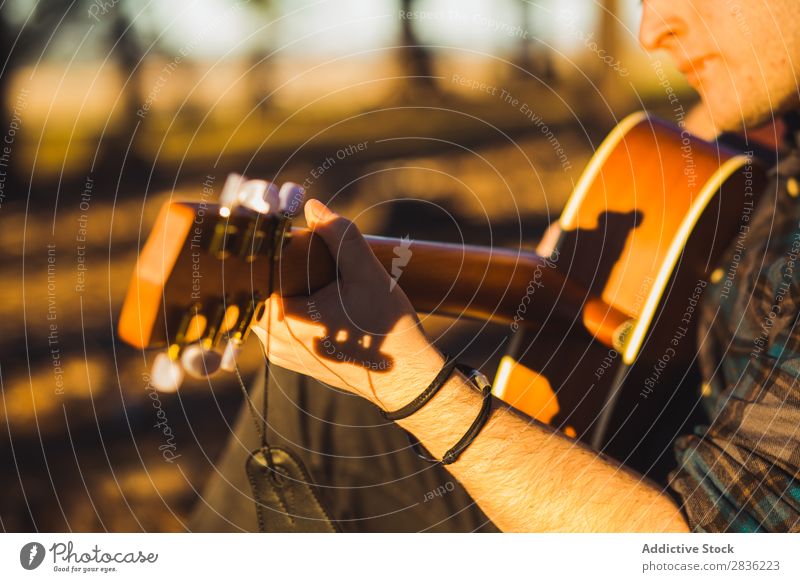 Mann spielt Gitarre in der Natur Musik Wald Sonnenstrahlen Tag anlehnen sitzen Rüssel Lifestyle Musiker lässig Gitarrenspieler akustisch Herbst Musical Mensch