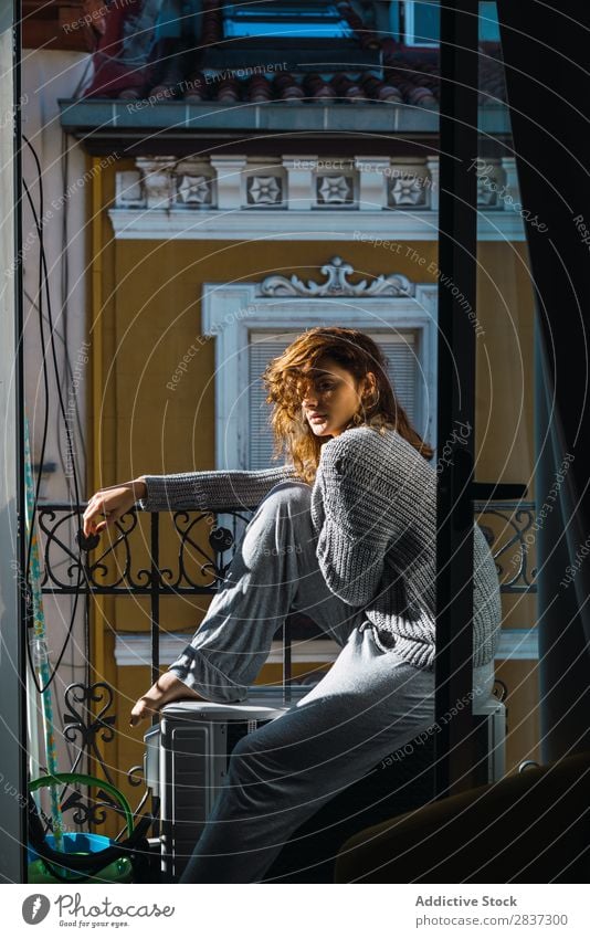 Junge Frau auf dem Balkon posierend heimwärts hübsch Erholung sitzen Jugendliche Körperhaltung Porträt schön Lifestyle Beautyfotografie attraktiv Dame Raum