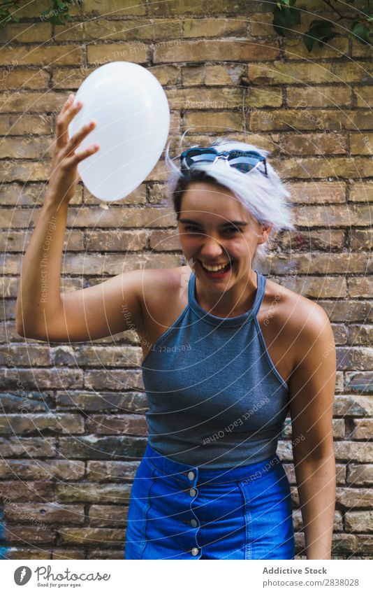 Charmante Frau posierend mit Ballon Körperhaltung Luftballon Straße lässig Sommer Gefühle Fröhlichkeit feminin Backsteinwand Zufriedenheit charmant Ausdruck