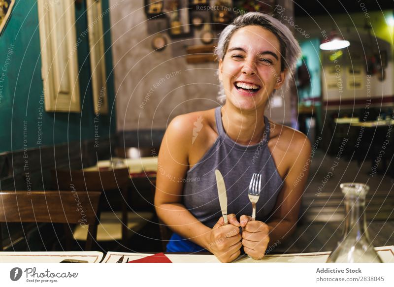 Wütendes Mädchen, das mit Silberwaren posiert. Frau Restaurant Appetit & Hunger Spaß haben Ausdruck Gesichtsbehandlung Gefühle humorvoll hysterisch Wut Café