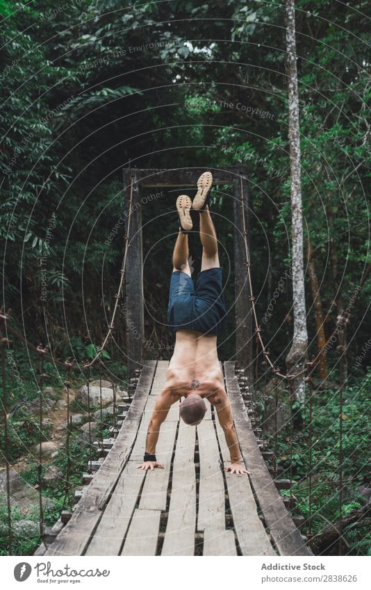 Mann auf dem Kopf auf einer schmutzigen Brücke Artist Natur extrem akrobatisch auf den Kopf gestellt auf Händen schäbig alt ohne Hemd Holz Gesundheit Lifestyle