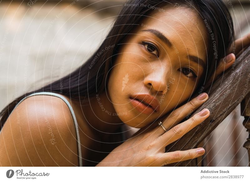 Nachdenkliche Frau am Holzhandlauf hübsch asiatisch Jugendliche Fürsorge besinnlich anlehnen Geländer schön Porträt attraktiv Beautyfotografie Mensch niedlich