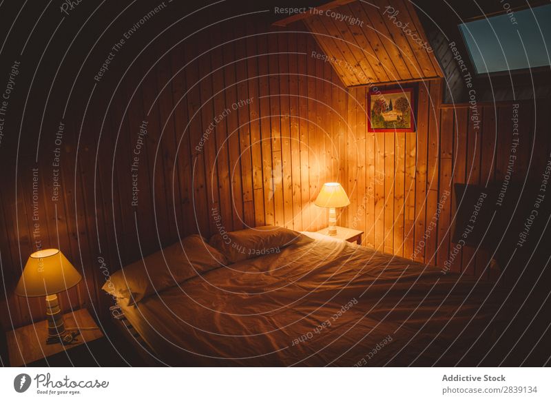 Schlafzimmerinnenraum mit brennenden Lampen Bett Innenarchitektur Wärme bequem Möbel heimwärts Wohnung Dekor Zeitgenosse Geborgenheit Licht Abend wohnbedingt