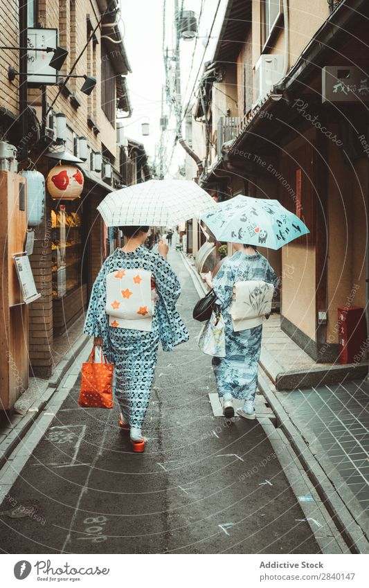 Frauen in asiatischer traditioneller Kleidung Tradition Bekleidung Regenschirm laufen Zusammensein Haus Holz heimwärts Asien Japaner Architektur altehrwürdig