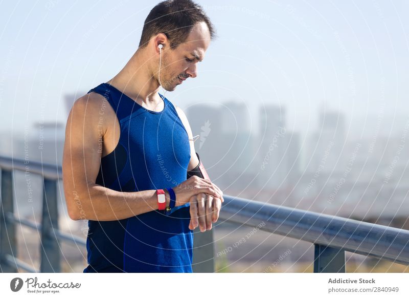 Der Läufer schaut auf seinen Puls mit Smartwatch. beobachten rennen Sport Zeit bewerten Bildschirm Mann Fitness Herz Training Gesundheit Sprint Joggen Sprinten