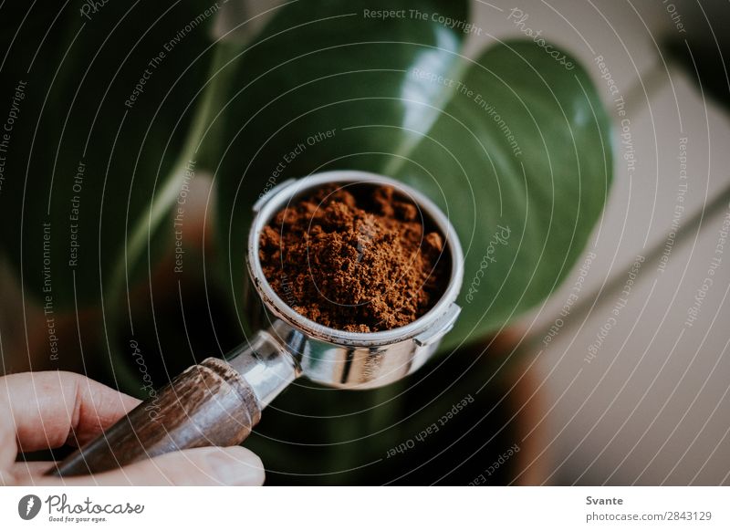 Nahaufnahme von Portafilter Kaffeetrinken Heißgetränk Latte Macchiato Espresso Lifestyle Berlin frisch Koffein gemahlener Kaffee Morgen vorbereitend Hand Halt