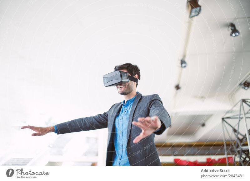 Ein Mann, der sich eine Virtual-Reality-Brille ansieht. Technik & Technologie cyber brünett Virtuelle Realität Kopf Anzeige Spielen realistisch Apparatur
