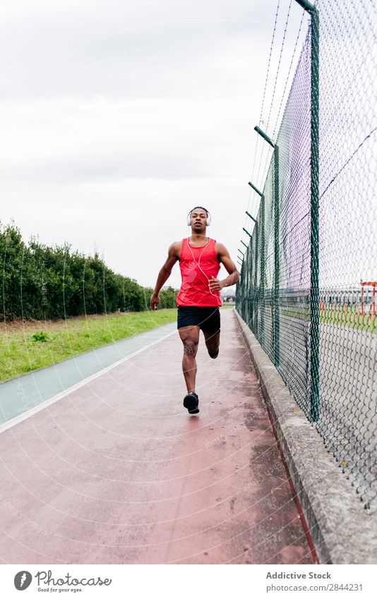 Mann läuft am Zaun entlang Joggen Bahn rennen Stadt Sportler Gesundheit Training Aktion Geschwindigkeit in Bewegung Natur üben sportlich Wellness schwarz