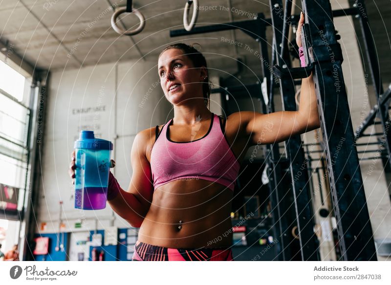 Lächelndes Mädchen beim Trinken im Fitnessstudio Frau trinken Sporthalle Erfrischung Gesundheit sportlich Körper Training Flasche Zufriedenheit heiter