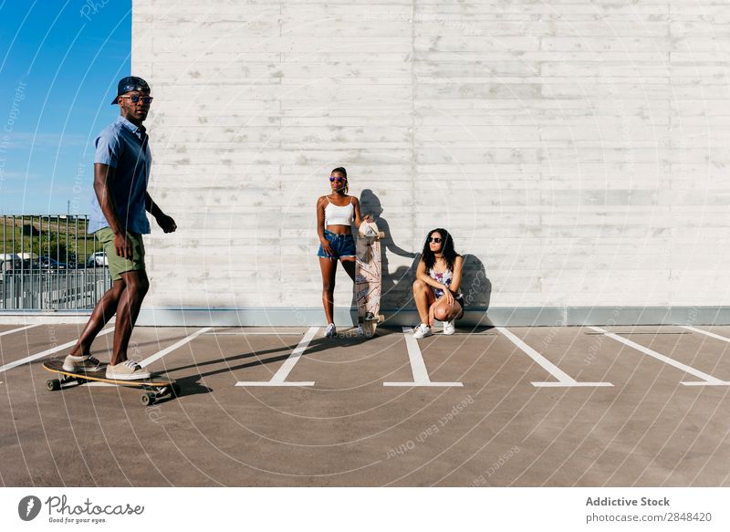 Sportliche Menschen mit Skateboards auf der Straße Körperhaltung Skateboarding Sommer Reiten Selbstständigkeit Menschengruppe in Bewegung sportlich Stil