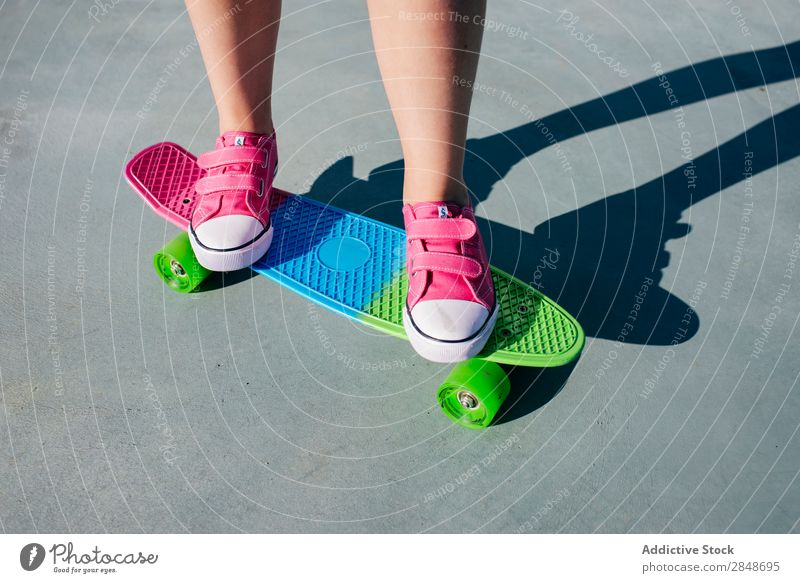 Crop Girl auf buntem Skateboard Frau mehrfarbig Longboard Bürgersteig Stil Sommer Turnschuh rosa lässig Youngster trendy Jugendliche Straße Stadt Beine modern