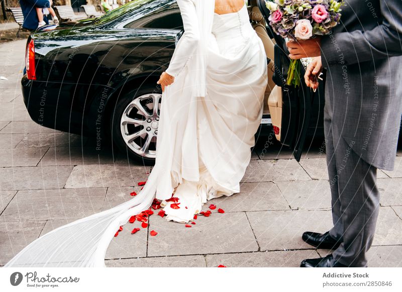 Braut steigt in das Auto ein striegeln PKW Hochzeit Liebe Paar Partnerschaft Blumenstrauß Fröhlichkeit romantisch Anzug hochzeitlich verheiratet Feste & Feiern