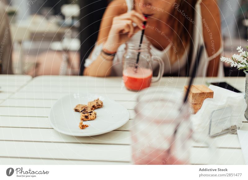 Mädchen trinken Cocktail mit Keksen Frau Milchshake Plätzchen Snack Tisch Trinkhalm süß Erfrischung natürlich gemischt Gesundheit Erholung Schokolade