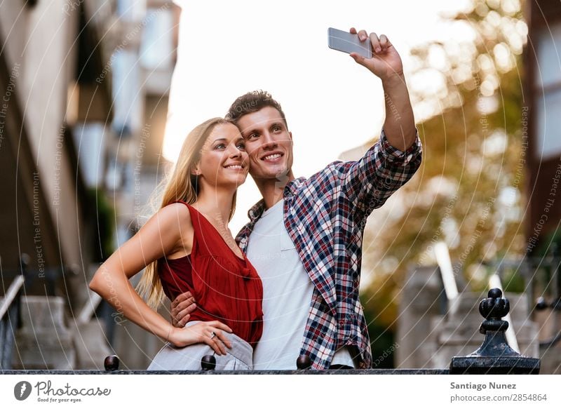 Romantisches junges Paar beim Fotografieren mit dem Handy. Selfie nehmen Jugendliche Telefon Mobile Solarzelle Selbstportrait Mensch Grafik u. Illustration