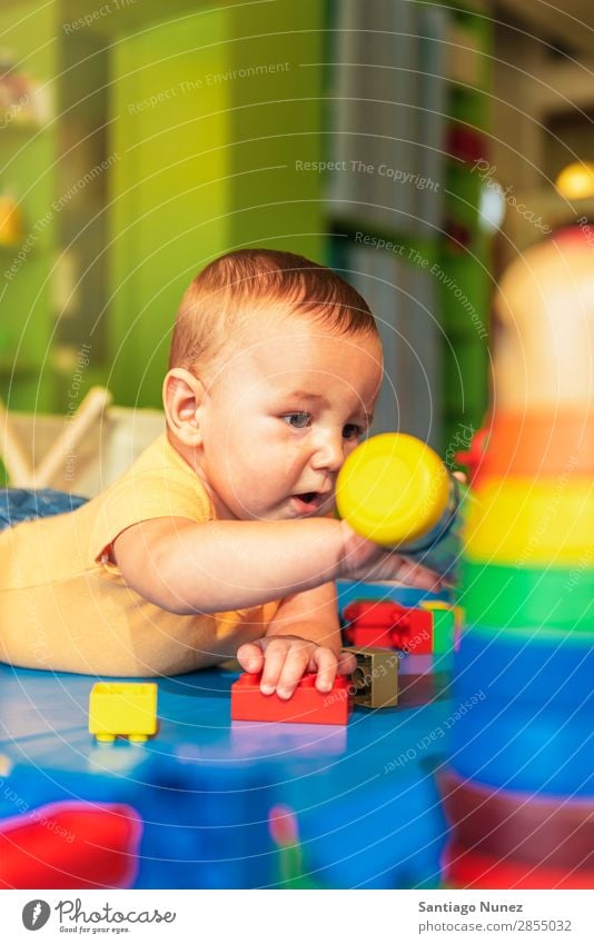 Glückliches Baby spielt im Kindergarten mit Spielzeugblöcken. Spielen Kinderbetreuung Schule Kleinkind Junge klein Fürsorge Etage niedlich Freude Vorschule