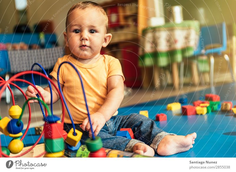 Frohes Baby beim Spielen mit Spielzeugblöcken. Kinderbetreuung Kindergarten Schule Kleinkind Junge klein LEGO Glück Fürsorge Etage niedlich Freude Vorschule