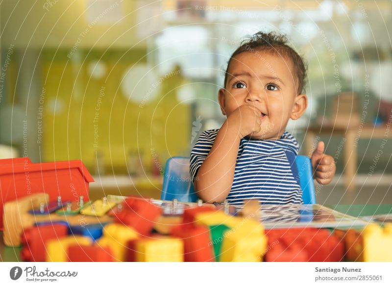 Frohes Baby beim Spielen mit Spielzeugblöcken. Kinderbetreuung Kindergarten Schule Kleinkind Mädchen klein Blöcke Lächeln Glück Fürsorge niedlich Freude
