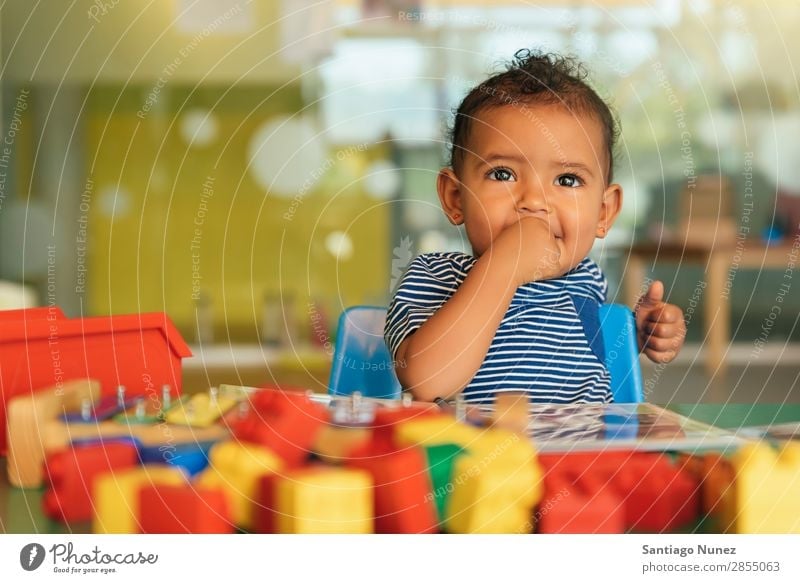 Frohes Baby beim Spielen mit Spielzeugblöcken. Kinderbetreuung Mulatte multiethnisch Kindergarten Porträt Schule Kleinkind Mädchen klein Blöcke Glück Fürsorge