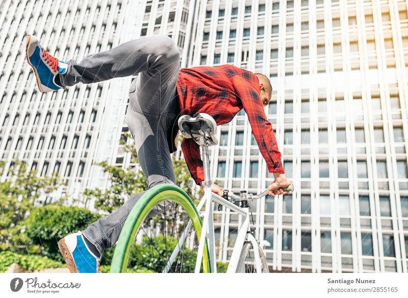 Gutaussehender junger Mann auf dem Fahrrad in der Stadt. Fixie Schickimicki Lifestyle Fahrradfahren Großstadt Solarzelle Mensch gutaussehend Stil Straße Porträt