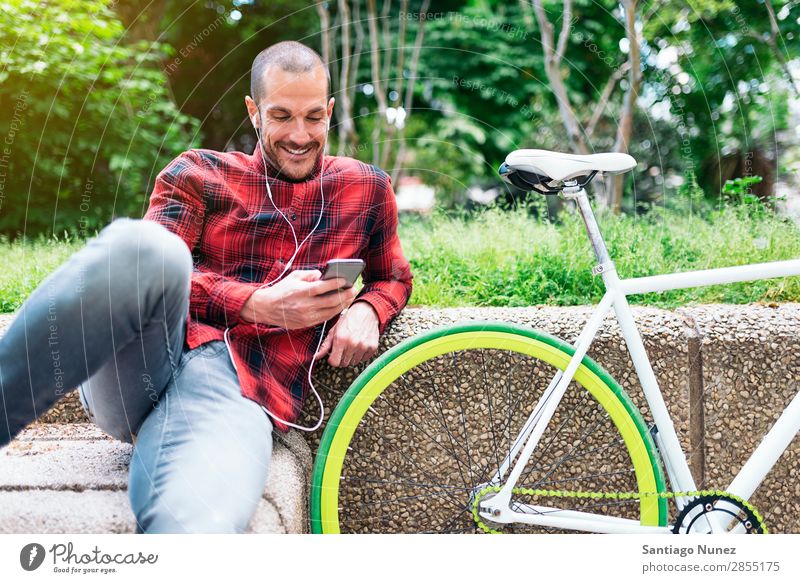 Junger Mann mit Mobiltelefon und Fahrrad mit festem Gang Mobile Fixie Telefon Hipster Lifestyle stehen Fahrradfahren Großstadt Gebäude Solarzelle Stadt Mensch