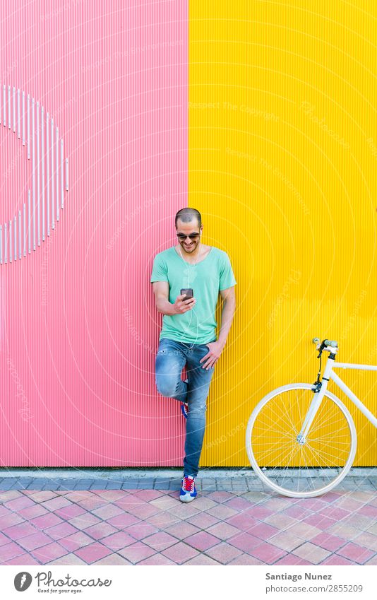 Gutaussehender junger Mann mit Handy und festem Fahrrad. Mobile Fixie Telefon Schickimicki Lifestyle stehen Fahrradfahren Großstadt Solarzelle Stadt Mensch