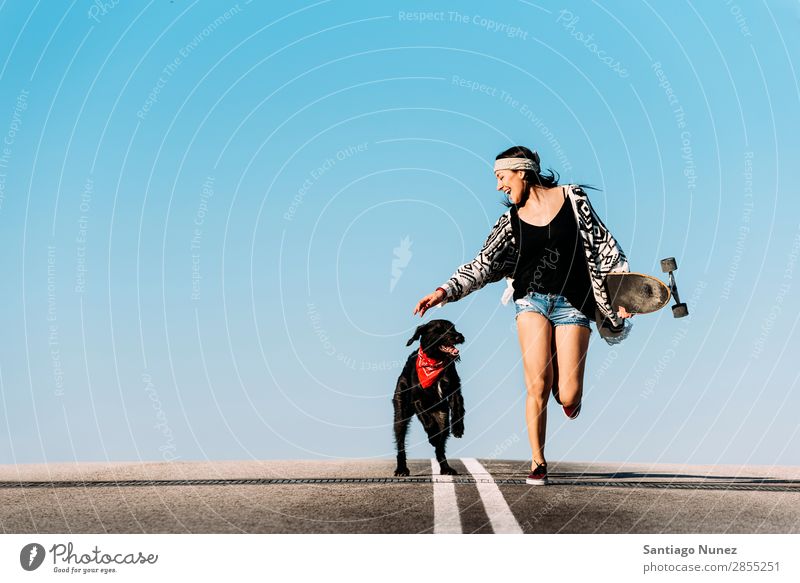 Ein wunderschöner junger Mann spielt mit ihrem Hund. Mädchen Frau Haustier Besitzer Schlittschuhlaufen Stadt Jugendliche Sport Skateboarding Longboard Reiten