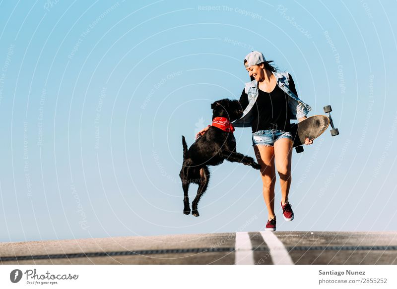 Ein wunderschöner junger Mann spielt mit ihrem Hund. Mädchen Frau Haustier Besitzer Schlittschuhlaufen Stadt Jugendliche Sport Skateboarding Longboard Reiten