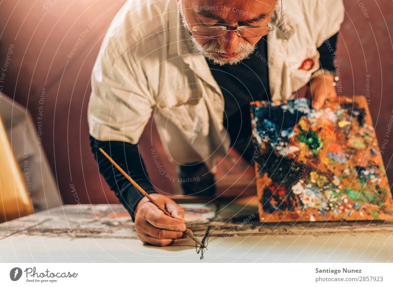 Alter Mann Künstler beim Malen von Ölen in seinem Atelier. Erwachsene Vollbart Maler konzentriert Gemälde Pinsel Bürste Staffelei Leinwand Konzentration