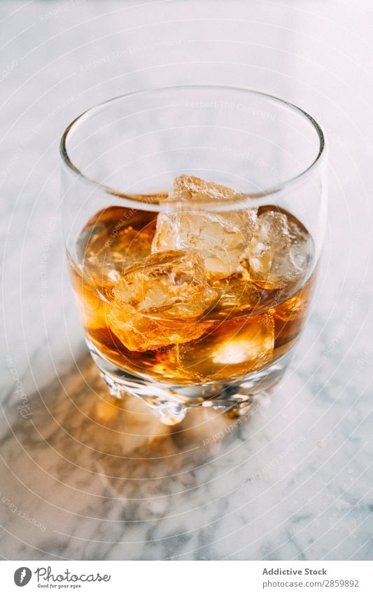 Ein Glas Whiskey auf Eis in Marmortisch Alkohol Amber Hintergrundbild Bar Barmann Barkeeper Getränk Flasche Bourbon Weinbrand Cognac trinken gold on the rocks