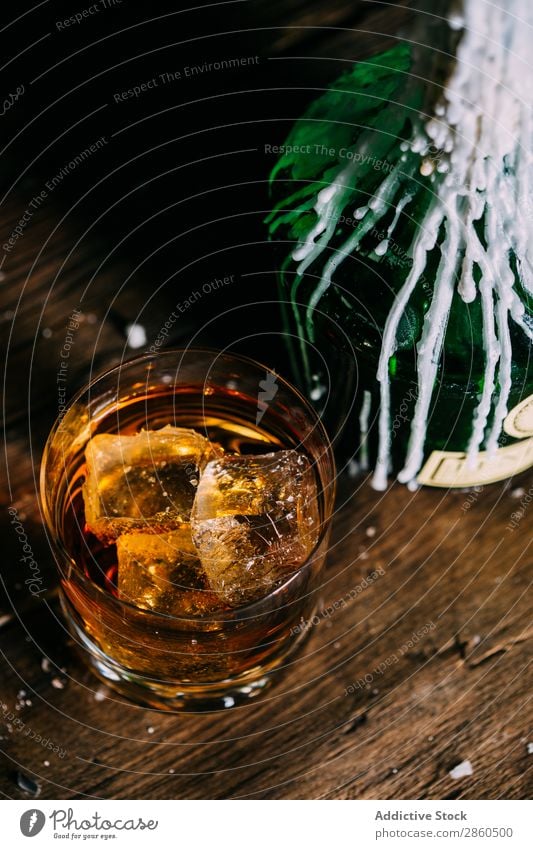 Ein Glas Whiskey auf einem Holztisch Alkohol Amber Hintergrundbild Bar Barmann Barkeeper Getränk Flasche Bourbon Weinbrand Cognac trinken gold Hand Eis