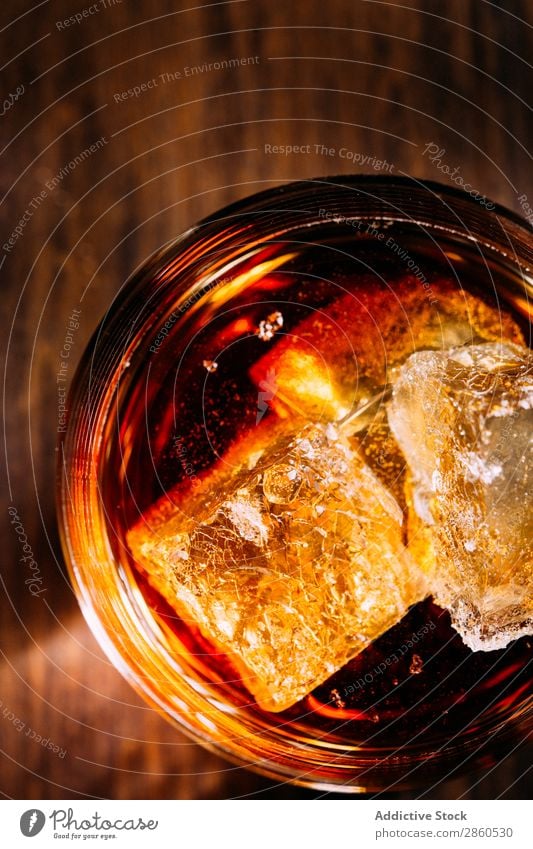 Ein Glas Whiskey auf einem Holztisch Alkohol Amber Hintergrundbild Bar Barmann Barkeeper Getränk Flasche Bourbon Weinbrand Cognac dunkel trinken gold Eis Rum