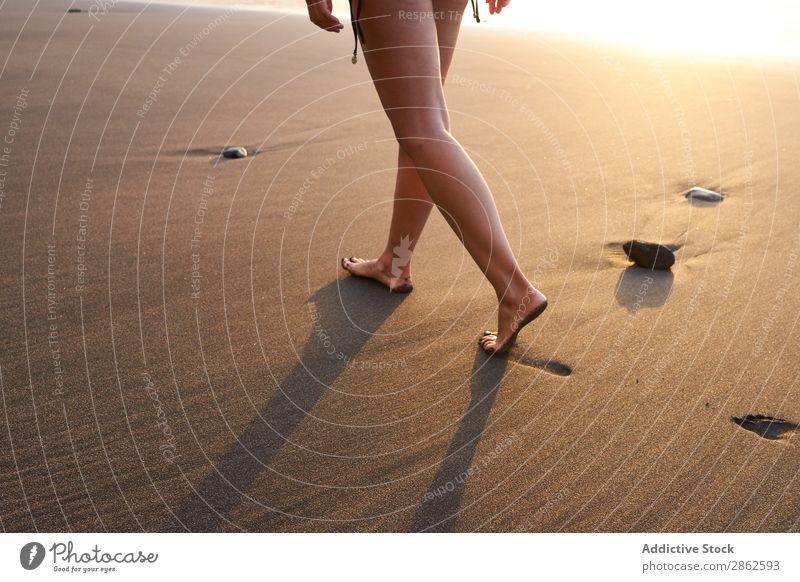 Getreidefrau, die auf dem Sand des Strandes spazieren geht. Frau Fußspur laufen Freitreppe Sonnenlicht abgelegen Sommer Meer sanft Küste Fußtritt